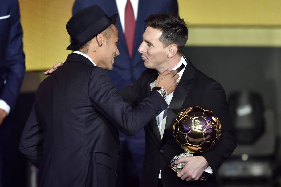 Neymar si congratula con il compagno Messi, entrambi vestono Armani. Afp